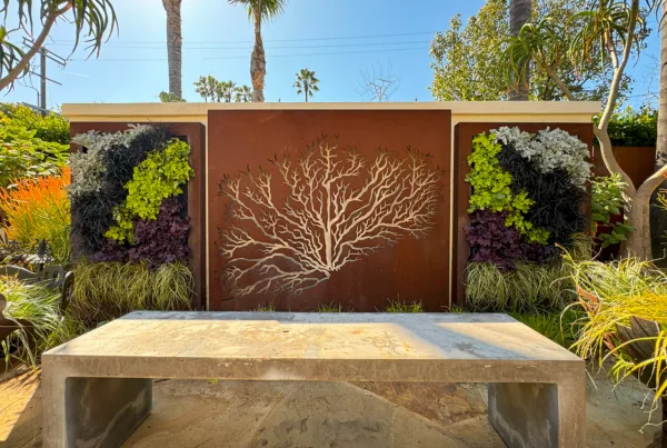 Vertical Garden Solutions living wall project for Brentwood, CA residence. Two outdoor living plant walls on both sides of a metal tree of life artwork.